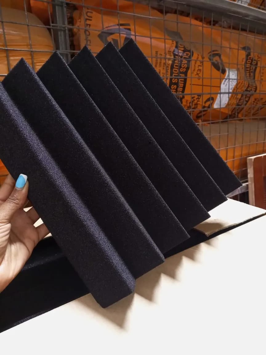 Black acoustic foam wedge panels held up in a warehouse
